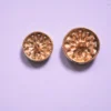 Close-up view of vintage gold floral metal buttons arranged on a clean background